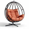 Hanging egg chair with orange cushion and metal frame for indoor outdoor use